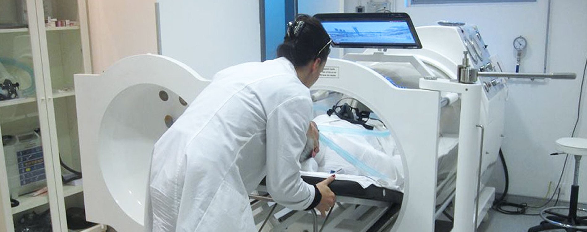 Paciente en sesión de oxigenación hiperbárica, asistido por personal médico
